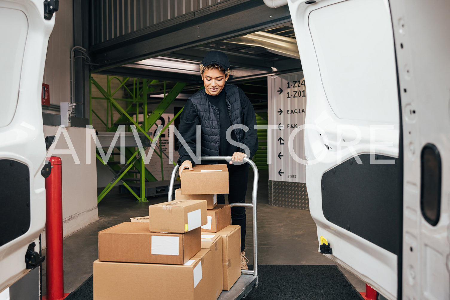 Woman in uniform checking cardboard boxes on a cart before putti