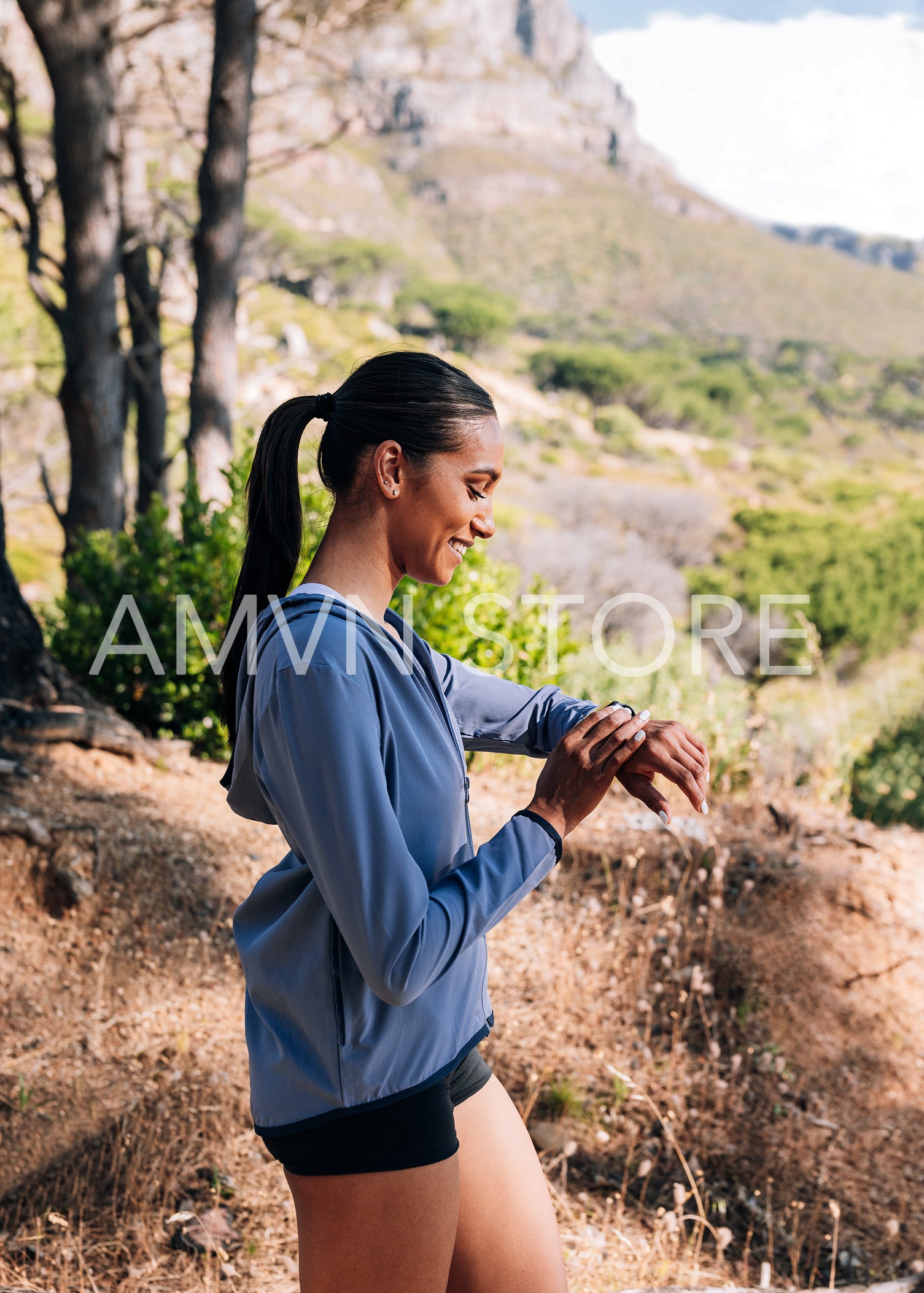 Side view of young and slim female in fitness wear checking her pulse on smartwatch