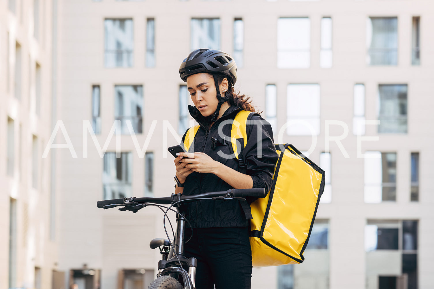 Woman courier with backpack checking information for delivery in the city