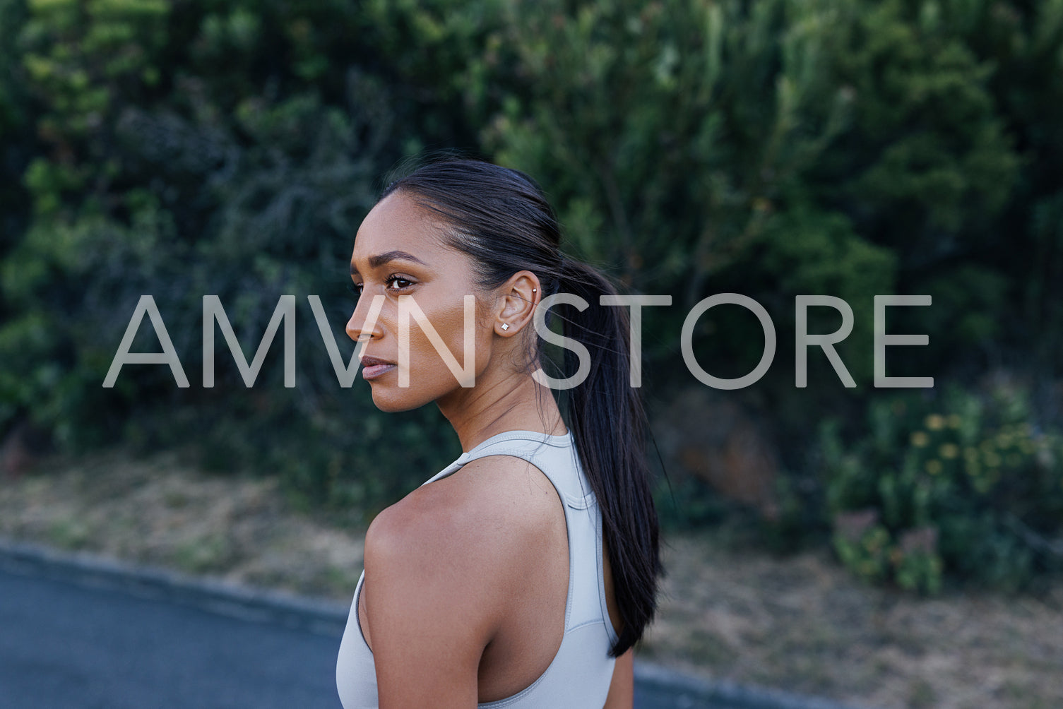 Portrait of a young woman athlete looking away. Young slim female posing outdoors while relaxing after exercise outdoors.