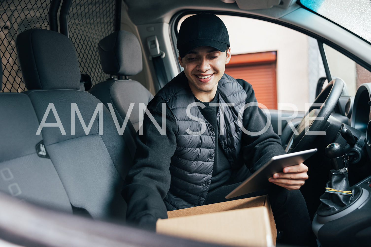 Male courier in preparing packages for transportation while sitt