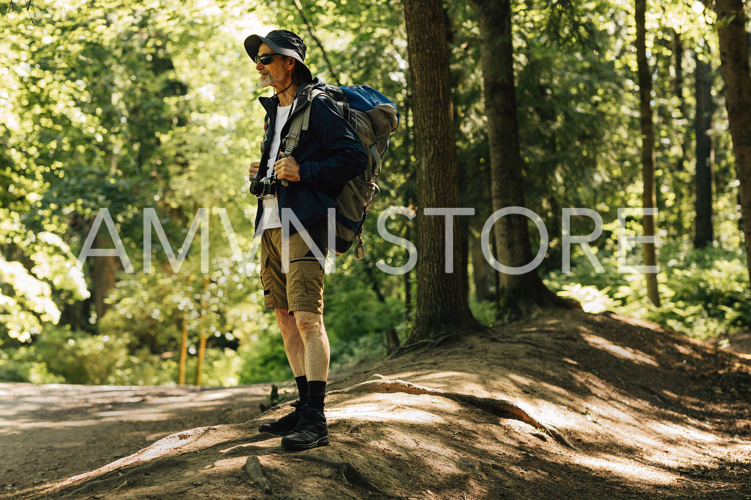 Full length of senior tourist wearing backpack and hat. Mature tourist looking for a place to camp.