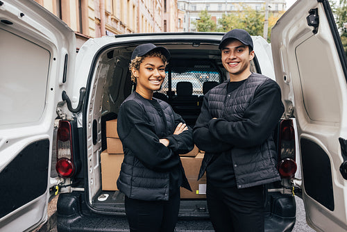 Portrait of a two confident and smiling couriers standing togeth