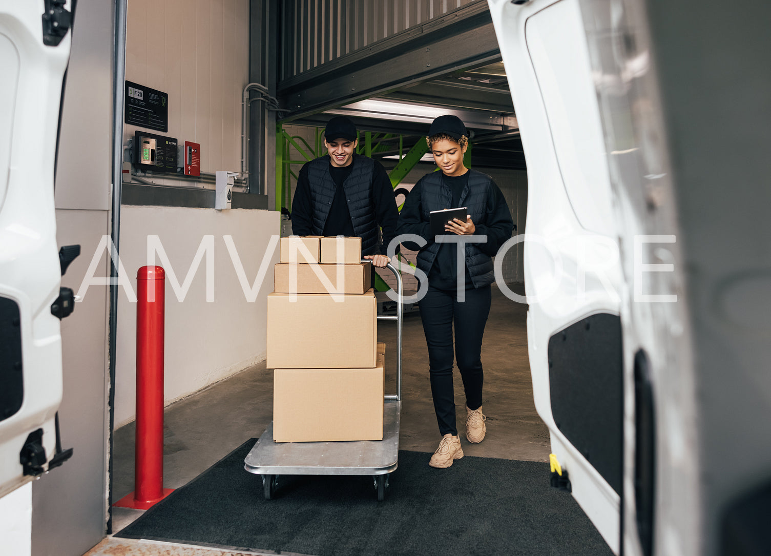 Two coworkers in the warehouse walking together with a cart