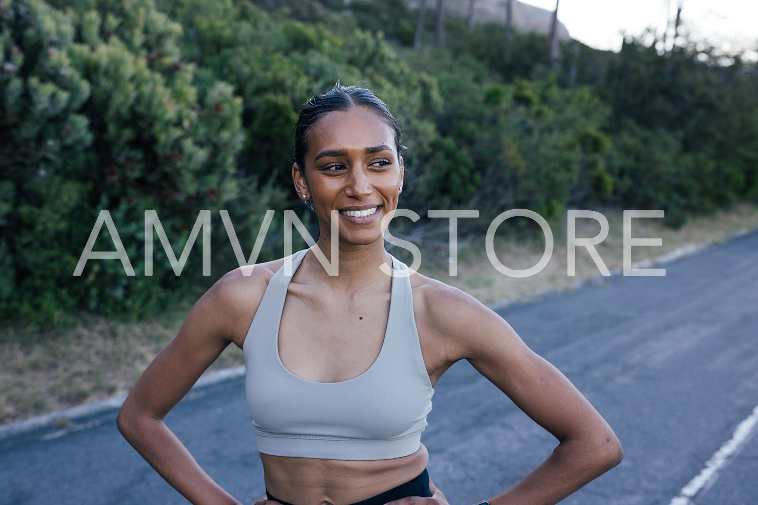 Portrait of a confident slim female looking away while relaxing during a workout in a natural park