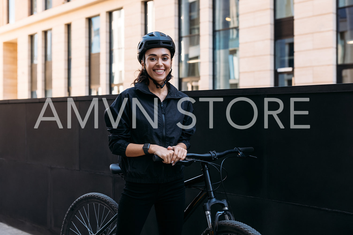 Beautiful smiling woman in black cycling helmet looking at camer