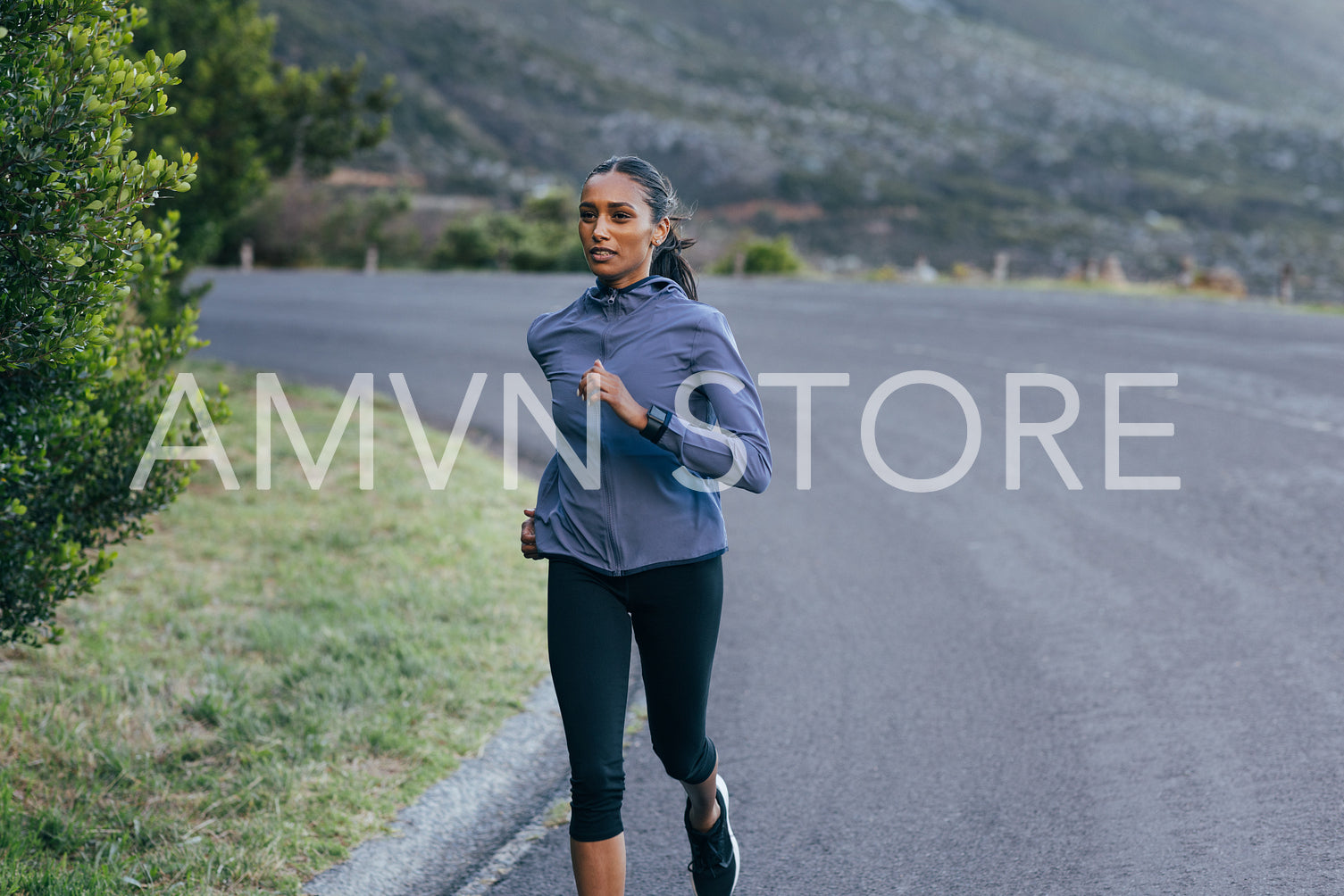 Slim woman runner on an abandoned road. Female in sportswear running on an empty road.