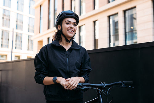 Portrait of a young female standing with a bicycle. Delivery wom