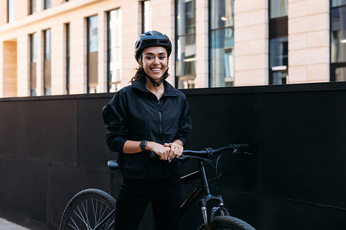 Beautiful smiling woman in black cycling helmet looking at camer