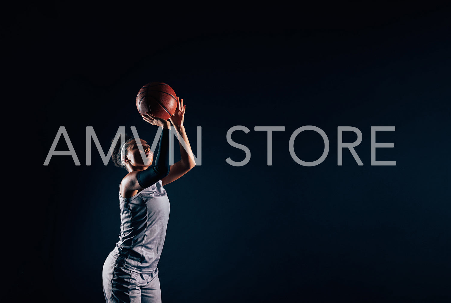 Professional female basketball player throwing basketball against black backdrop. Woman basketball player is ready to throw a ball.