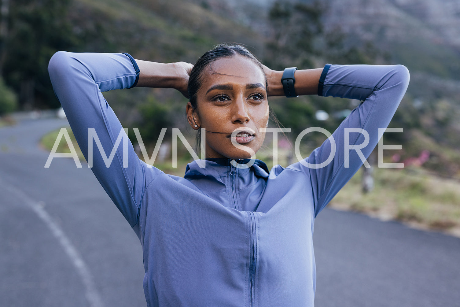 High-detailed portrait of a young female in sportswear and smartwatches on her wrist. Female relaxing after exercising in a natural park.