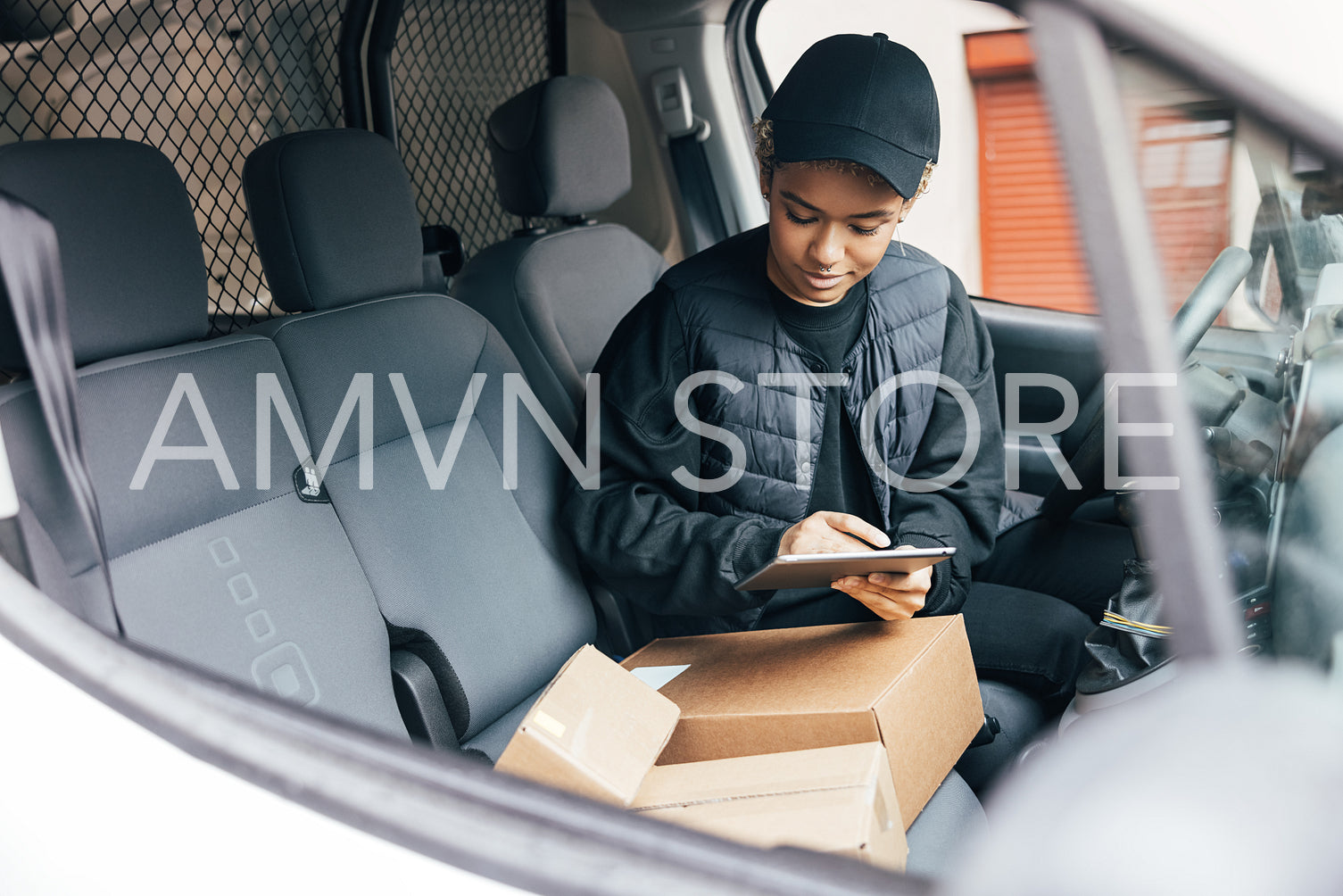 Woman in a uniform of a delivery company checking information on