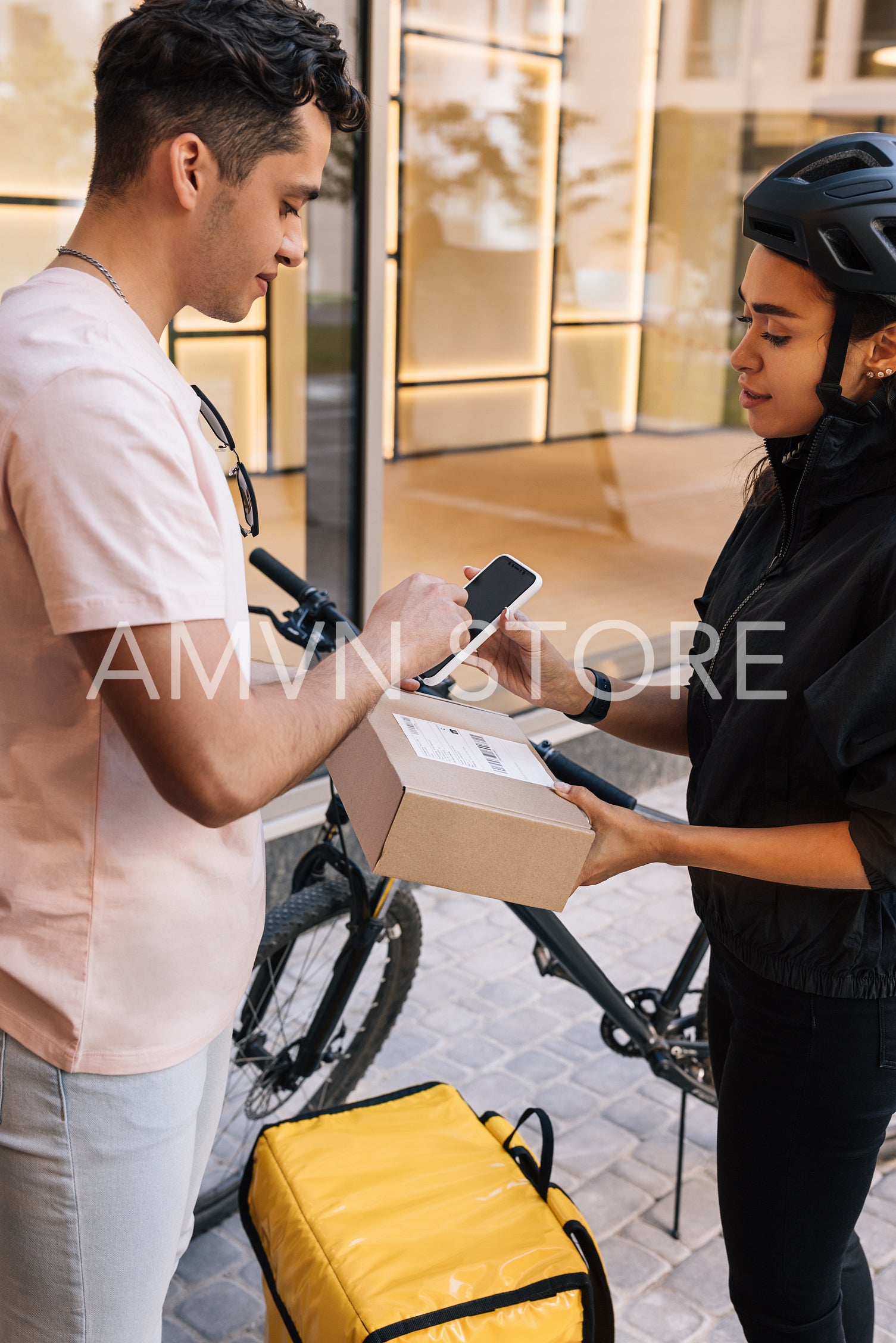 Young woman delivered a parcel to a customer. Customer sign proof of delivery on a smartphone.