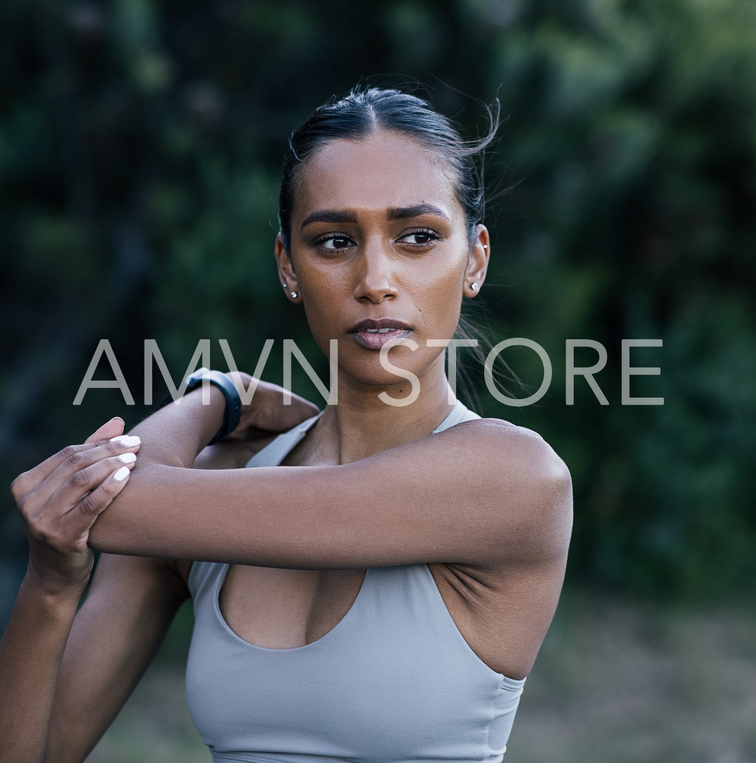 Portrait of young slim athlete warming up upper body while standing outdoors 