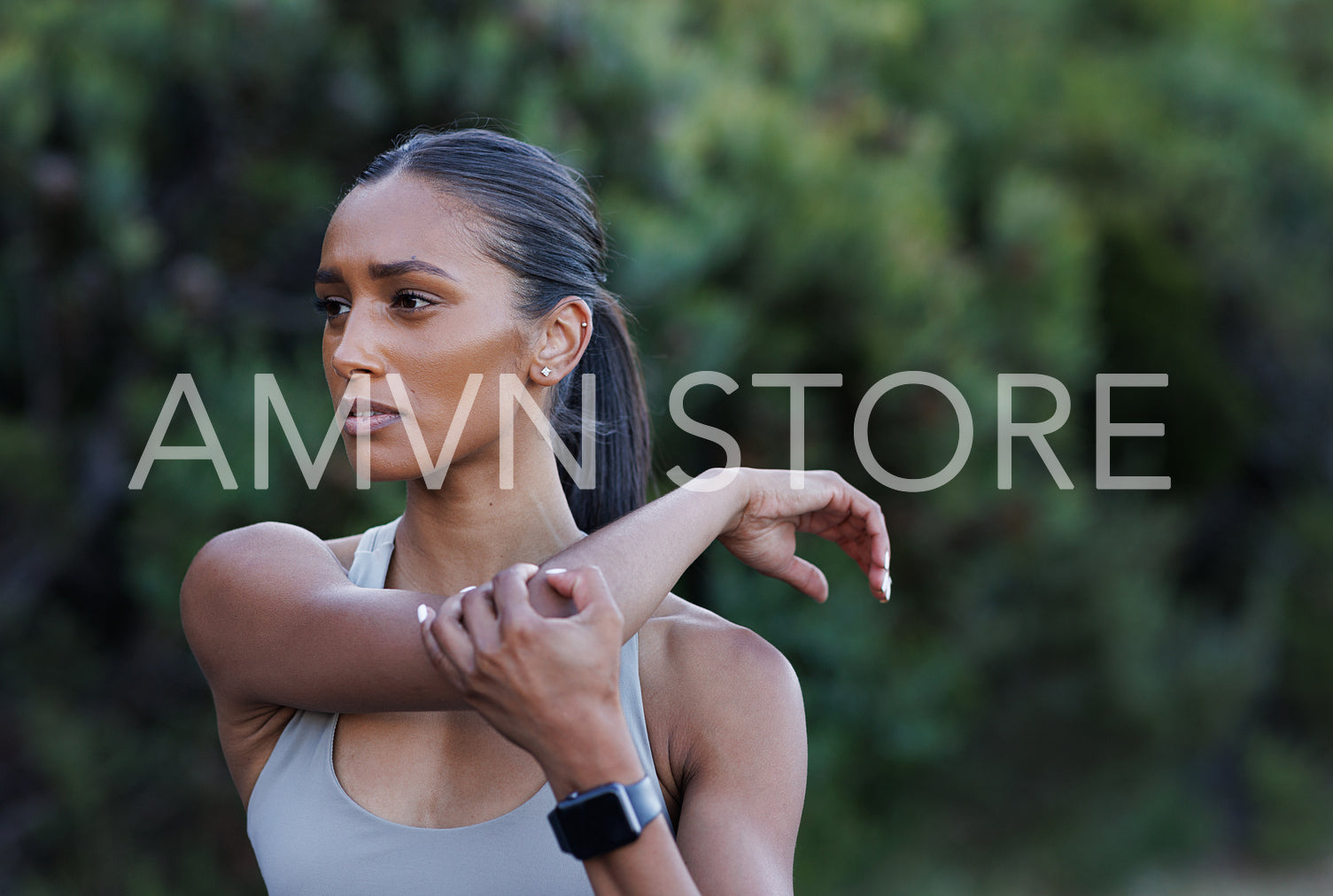 Close-up portrait of a young slim woman stretching her hand. Female warming up the upper body before a workout.