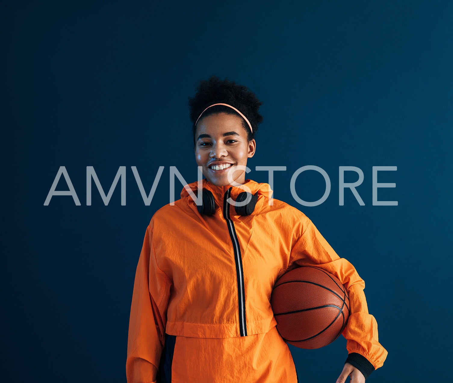 Smiling and confident professional basketball player wearing orange sportswear looking at camera