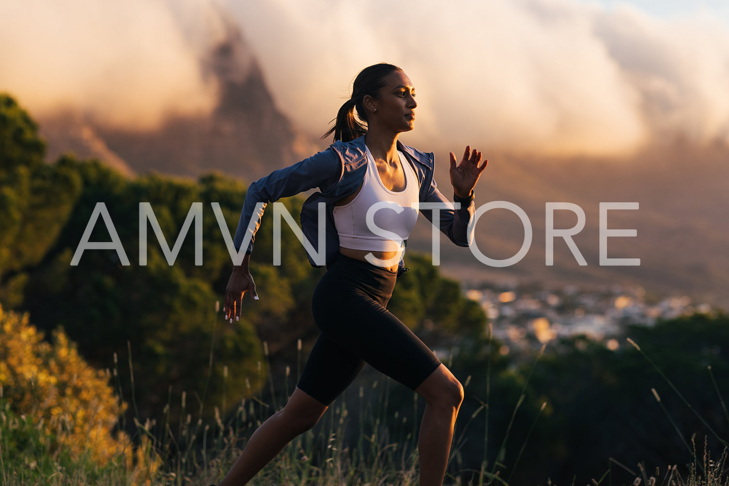 Slim female runner exercising against stunning sunset. Woman in sportswear running at sunset outdoors.