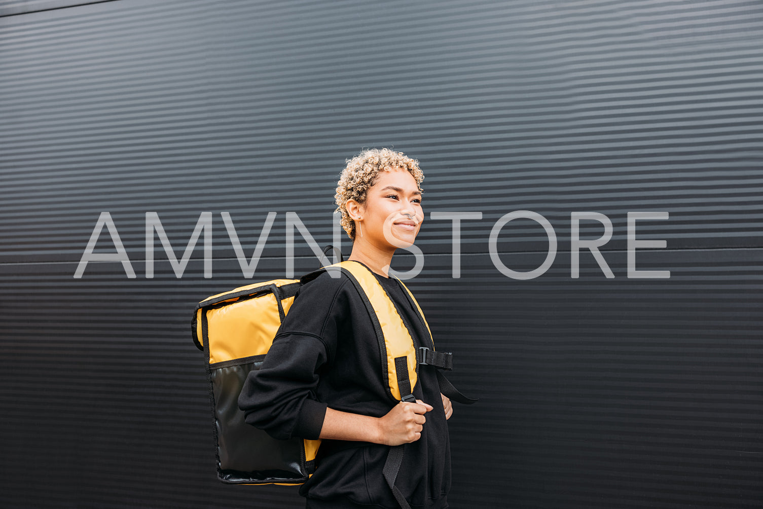 Portrait of delivery girl holding yellow thermal delivery backpa