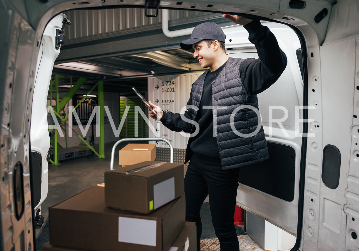 Young man holding a digital tablet while standing at van. Courie