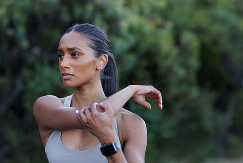 Close-up portrait of a young slim woman stretching her hand. Female warming up the upper body before a workout.