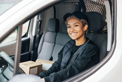 Portrait of a smiling woman working for delivery company sitting