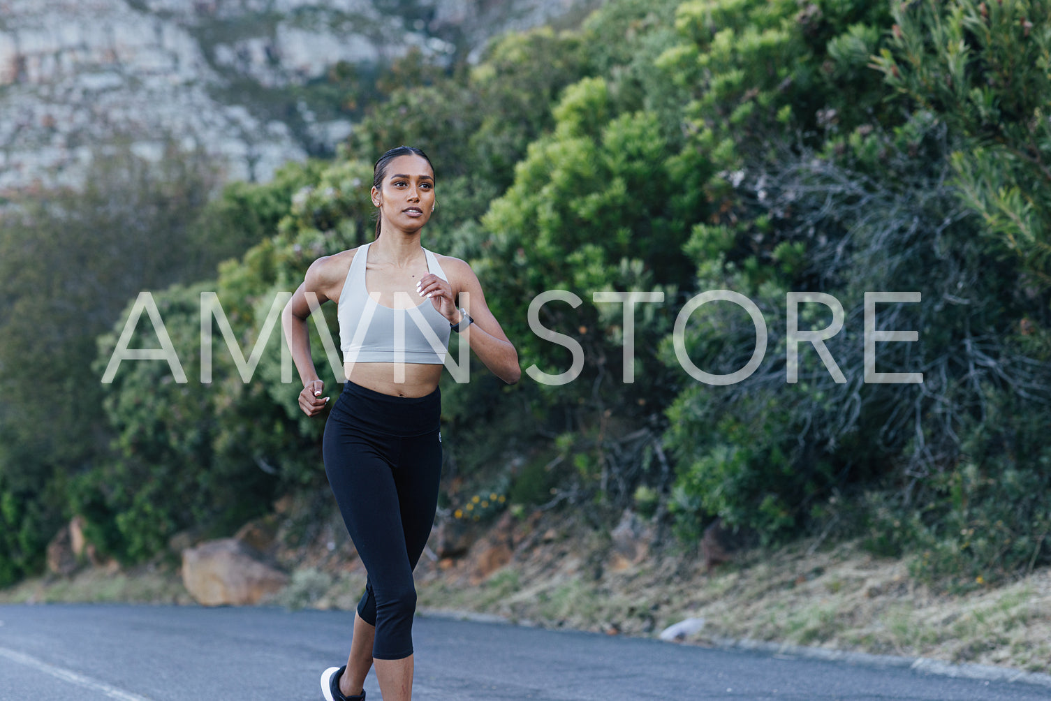 Young female runner practicing outdoors. Slim jogger in fitness wear runner on an abandoned road.