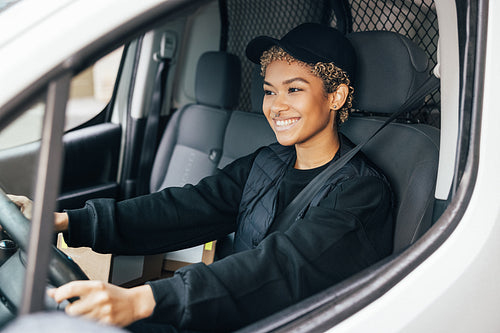 Portrait of a young woman working for a delivery service, sittin