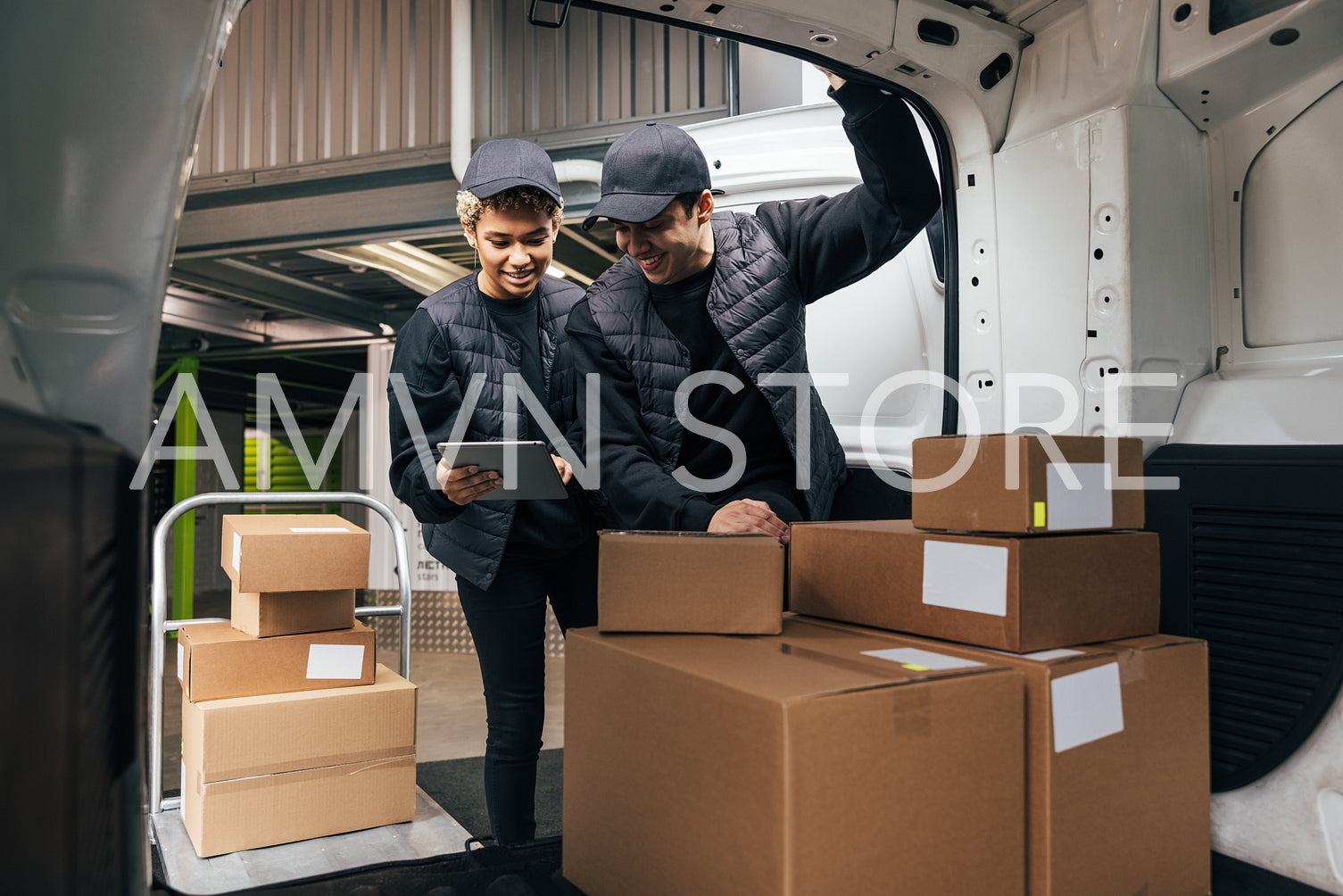 Two couriers in uniform standing at car trunk in warehouse check