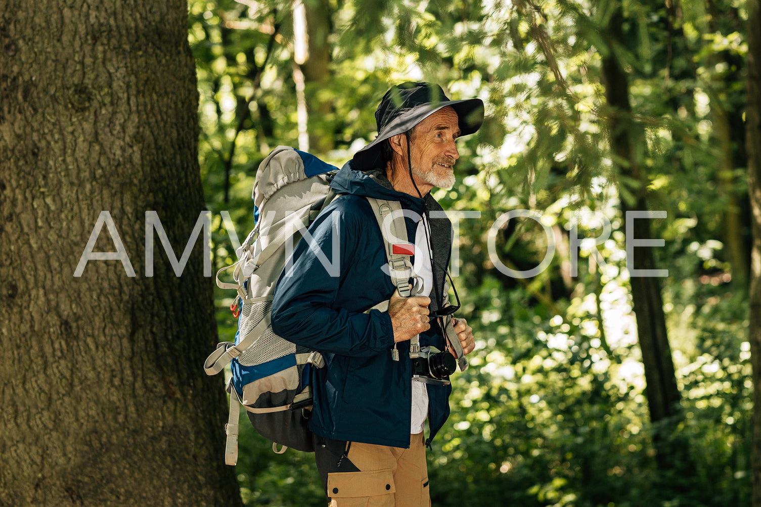 Senior male with backpack and hiking clothes walking in forest