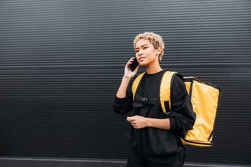 Portrait of a delivery girl with yellow thermal backpack on her