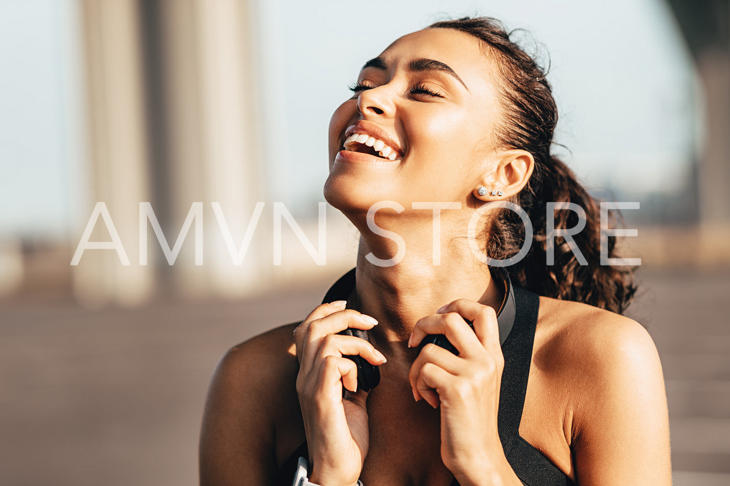 Happy female runner with headphones around her neck	