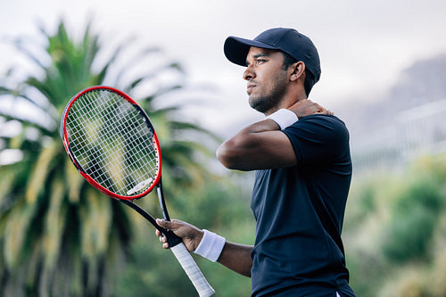 Professional tennis player touching his neck during a match