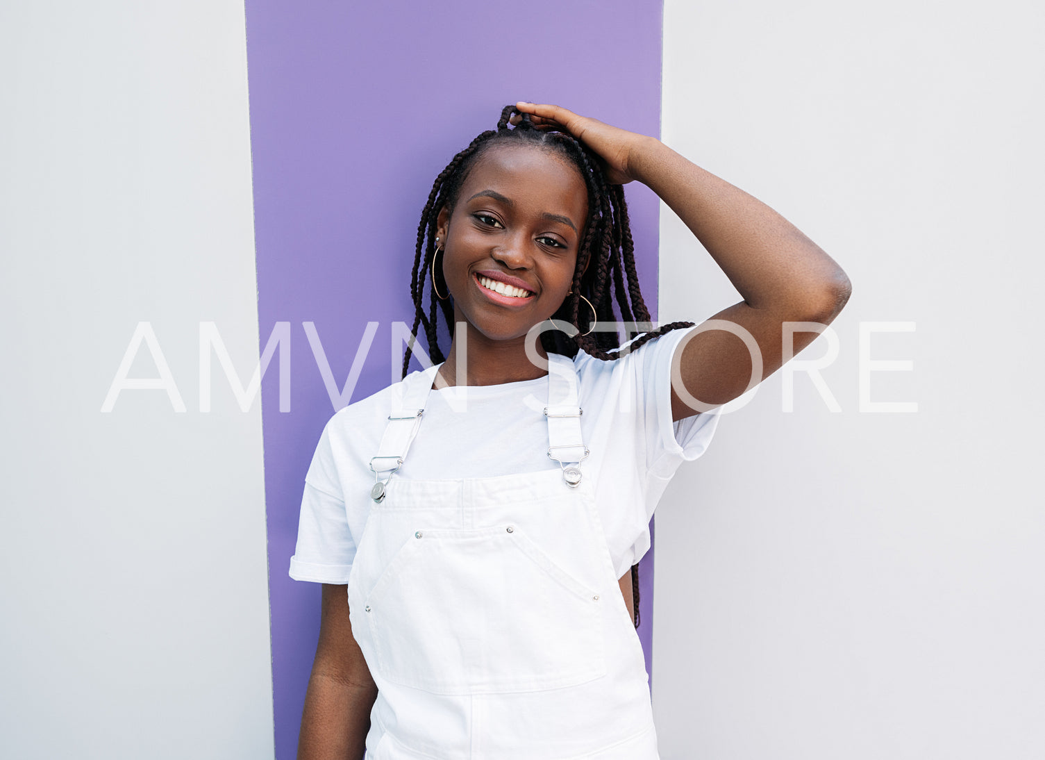 Happy woman with braids wearing white casual clothes and looking at camera outdoors