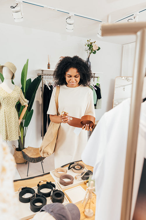 Stylish woman choosing accessories for clothes in a small local boutique