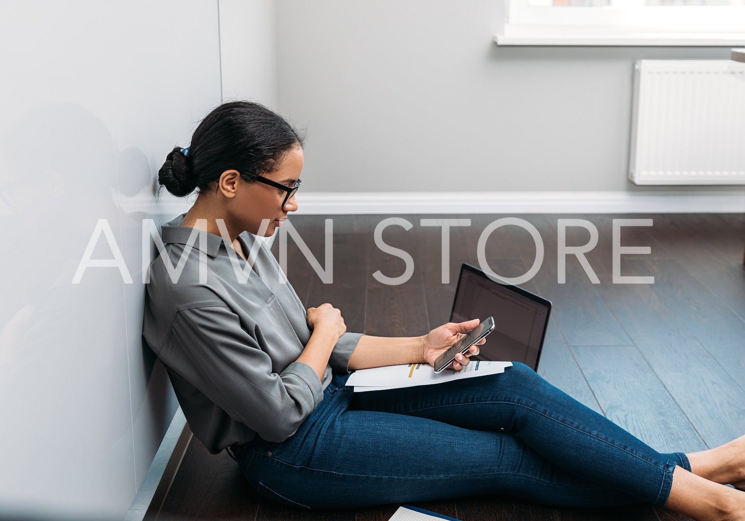 Side view of a young woman counting bills while sitting on a floor at home