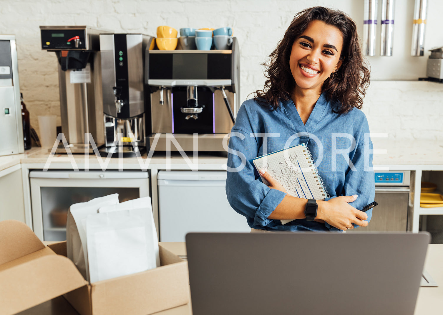 Portrait of a happy female coffee shop owner. Businesswoman holding a notebook in the cafe and looking at camera.	