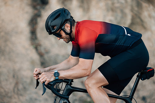 Side view of a cyclist putting effort during training outdoors.Male athlete riding a bicycle.