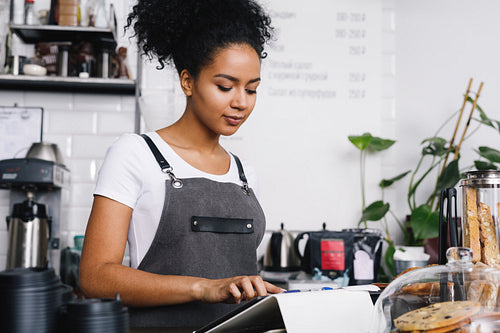 Young businesswoman makes an order for her cafeteria, using digital tablet