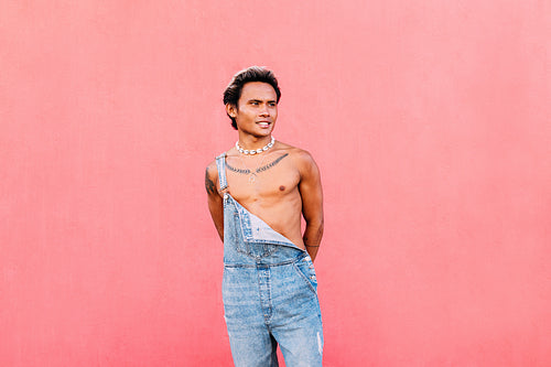 Young handsome man posing outdoors while standing at wall