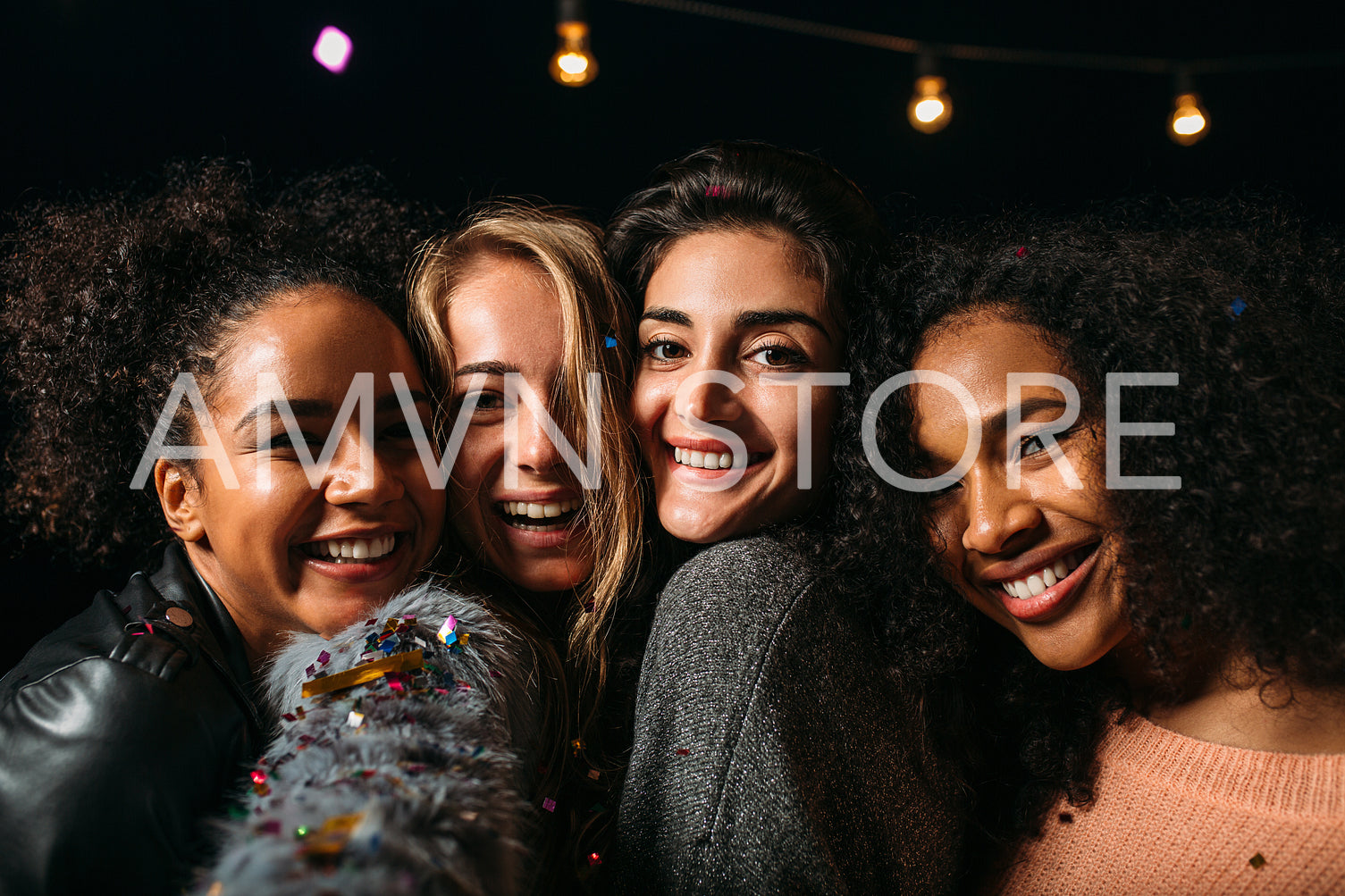 Portrait of a group of diverse women smiling and looking at the camera at night