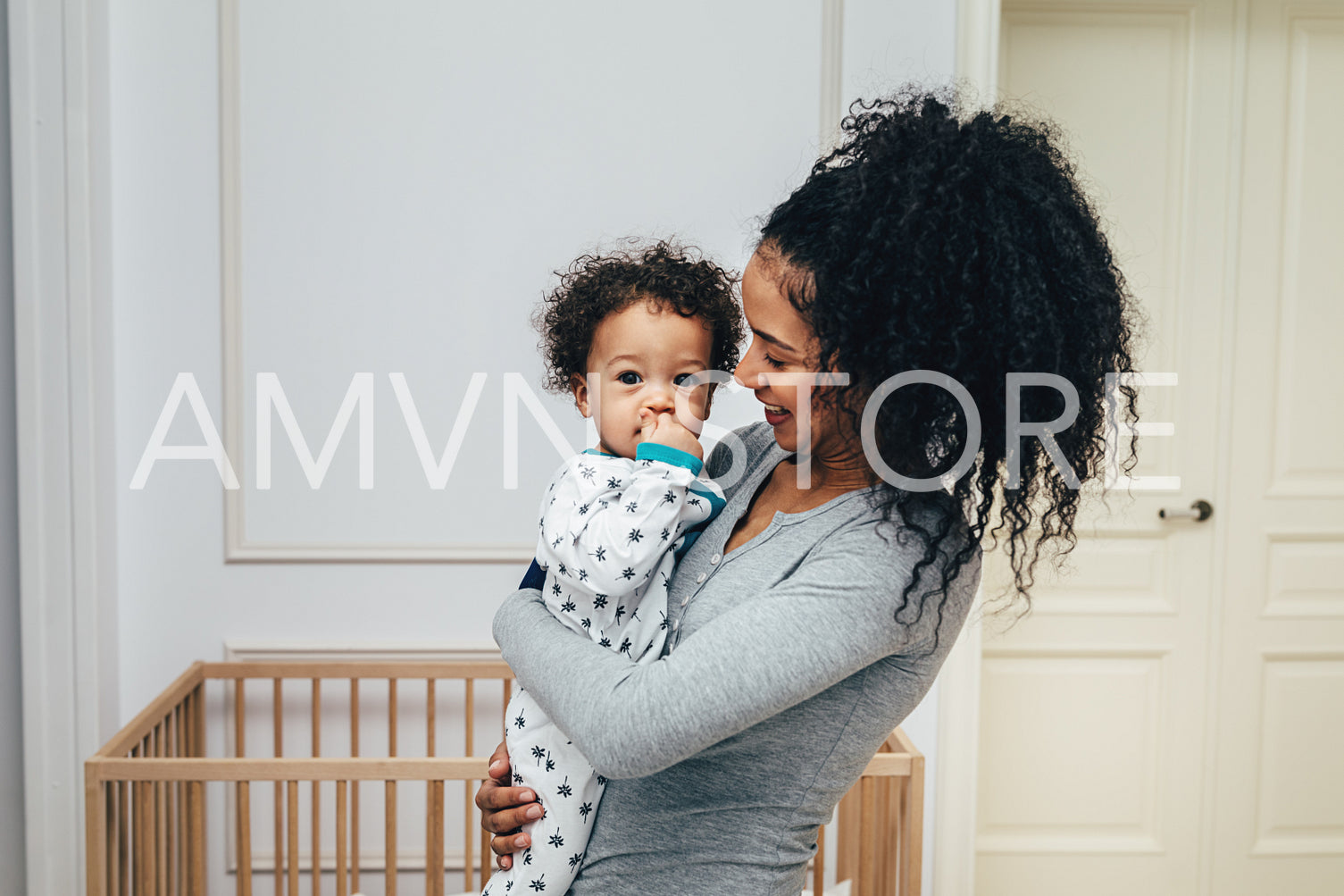 Smiling mother holding her child in living room	