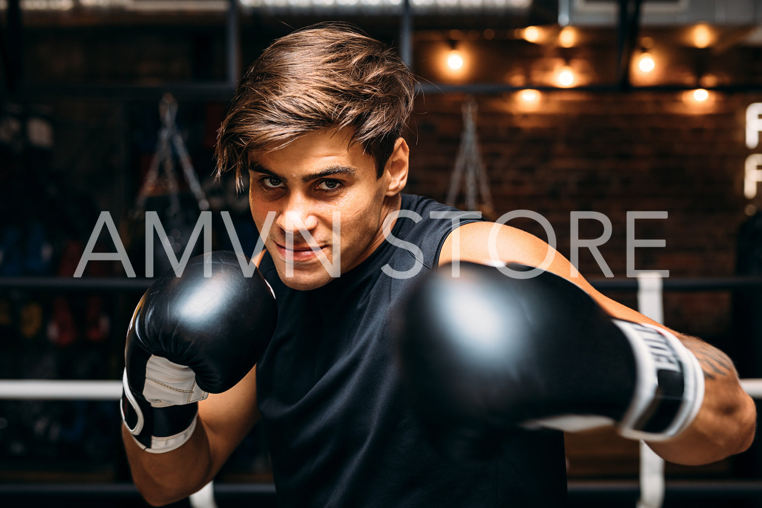 Close up of a young male boxer with boxing gloves punching towards camera	