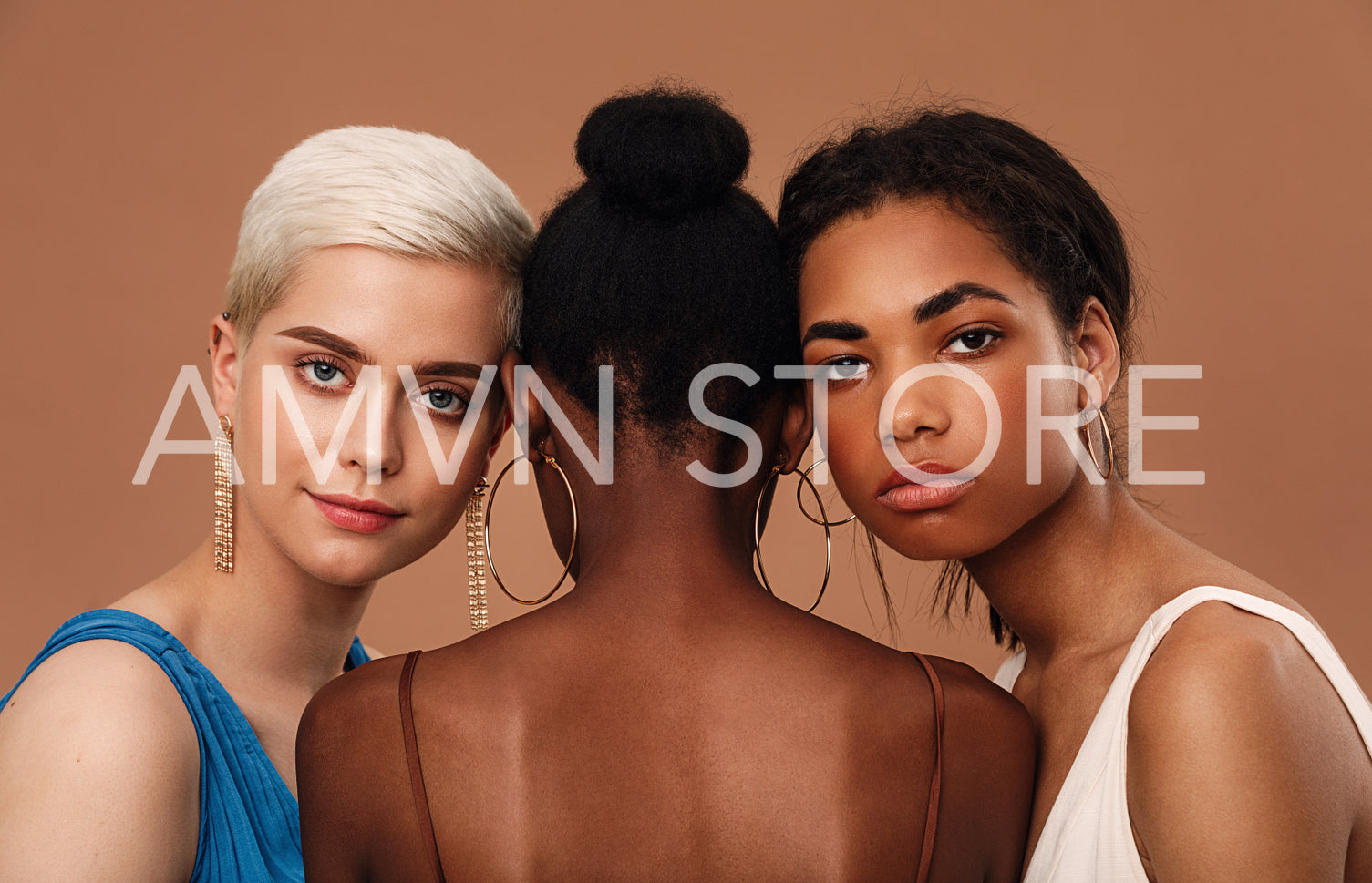 Studio shot of a thee diverse women against brown background	