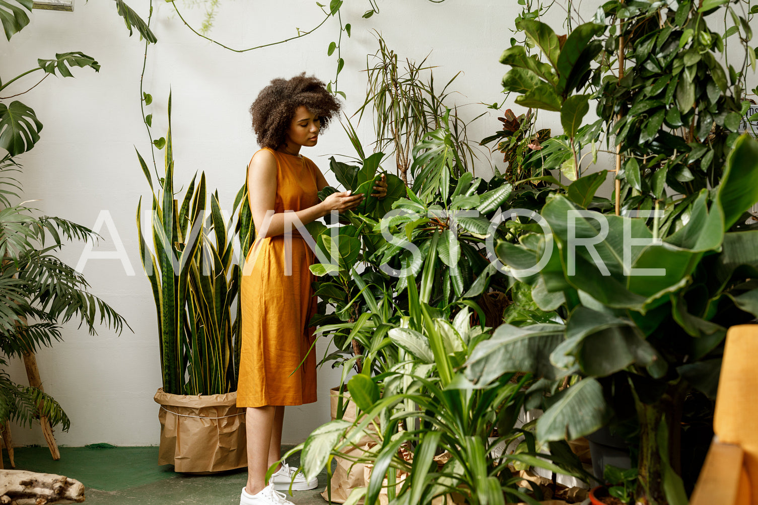 Young woman holding a book and observe a plant in workshop	