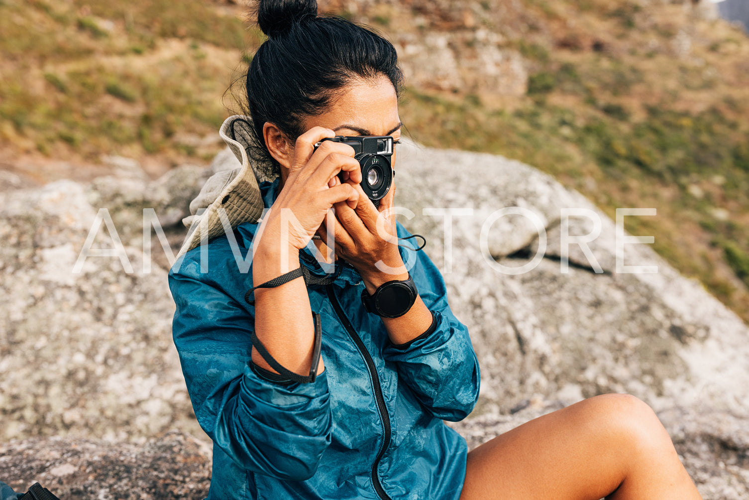 Young female taking photographs of the landscape with a film cam