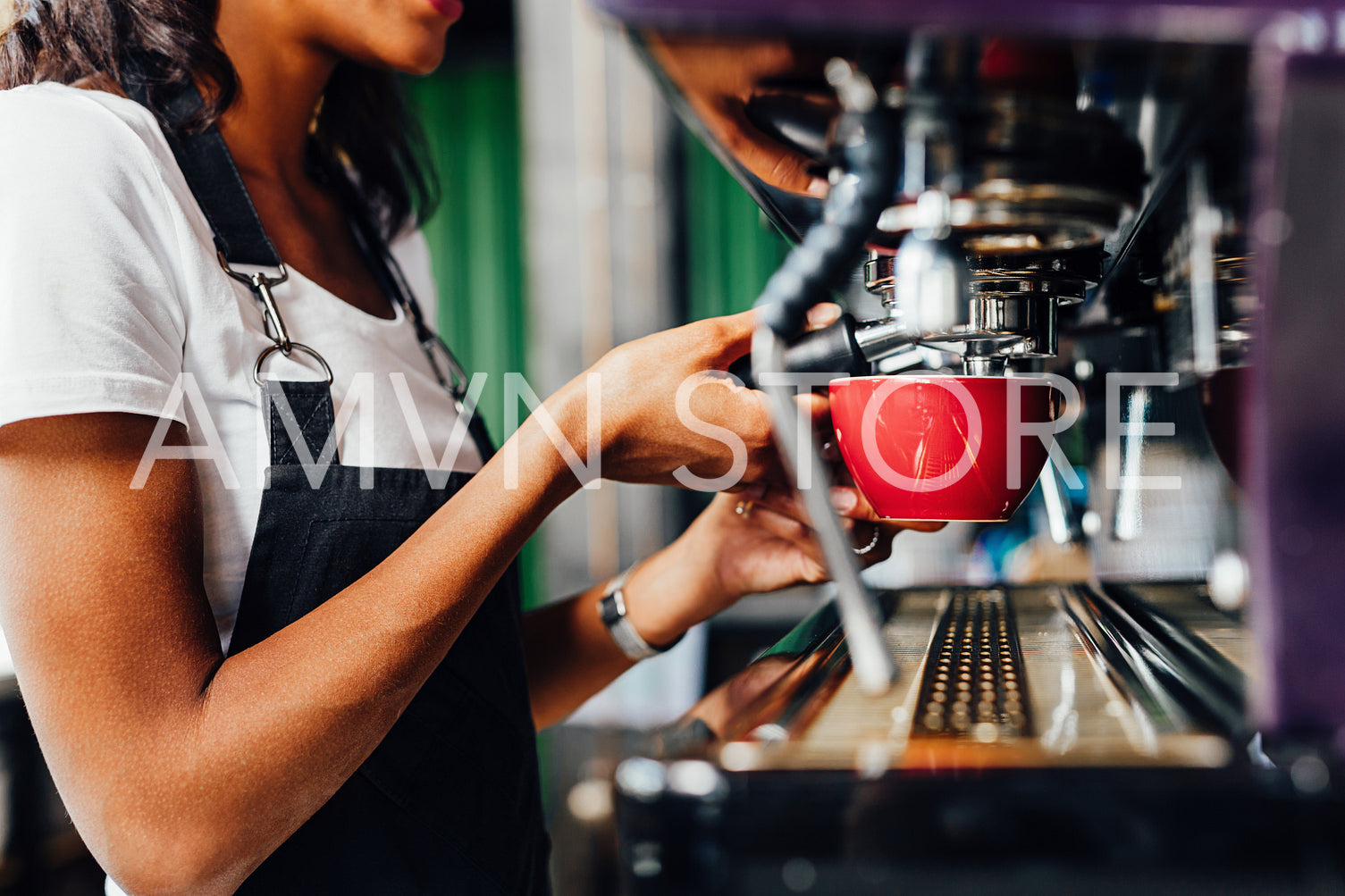 Unrecognizable female barista using a coffee maker to prepare a espresso	