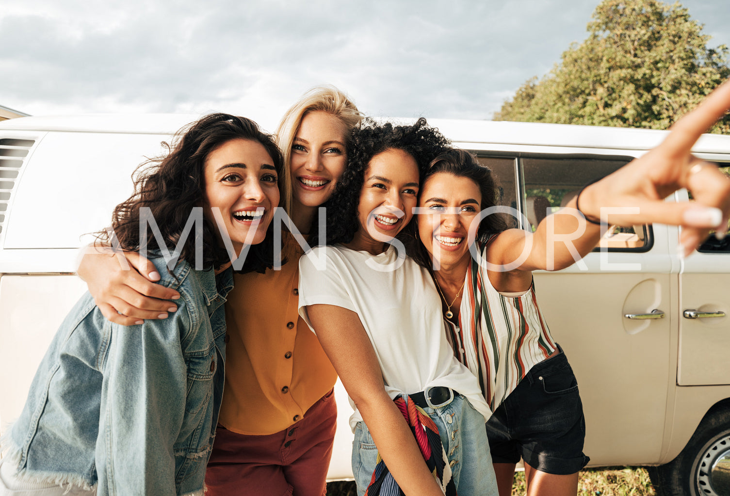 Group of young laughing women stopped during a road trip 