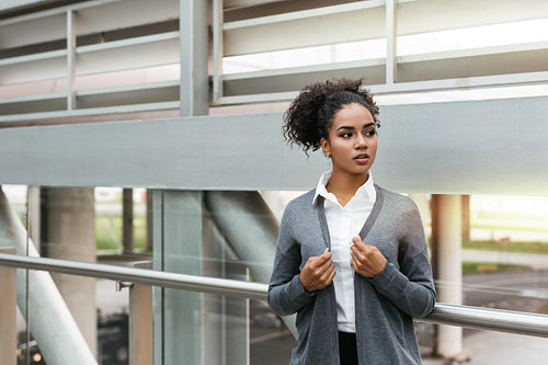 Serious businesswoman standing in airport terminal, looking away