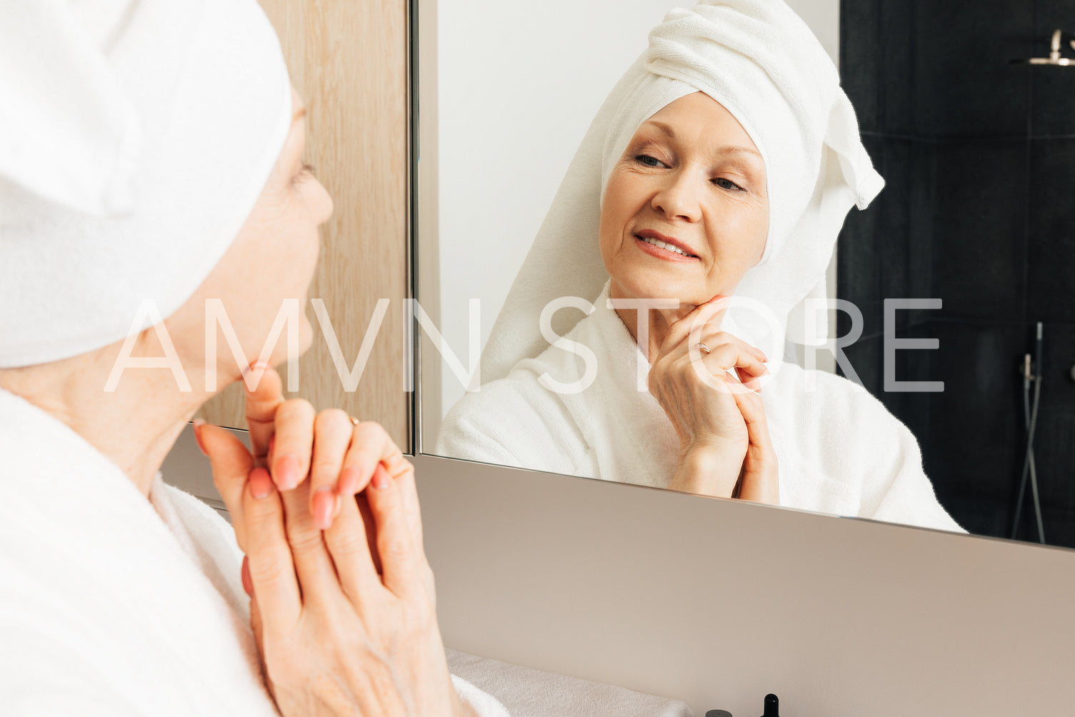 Aged woman admire her face in bathroom