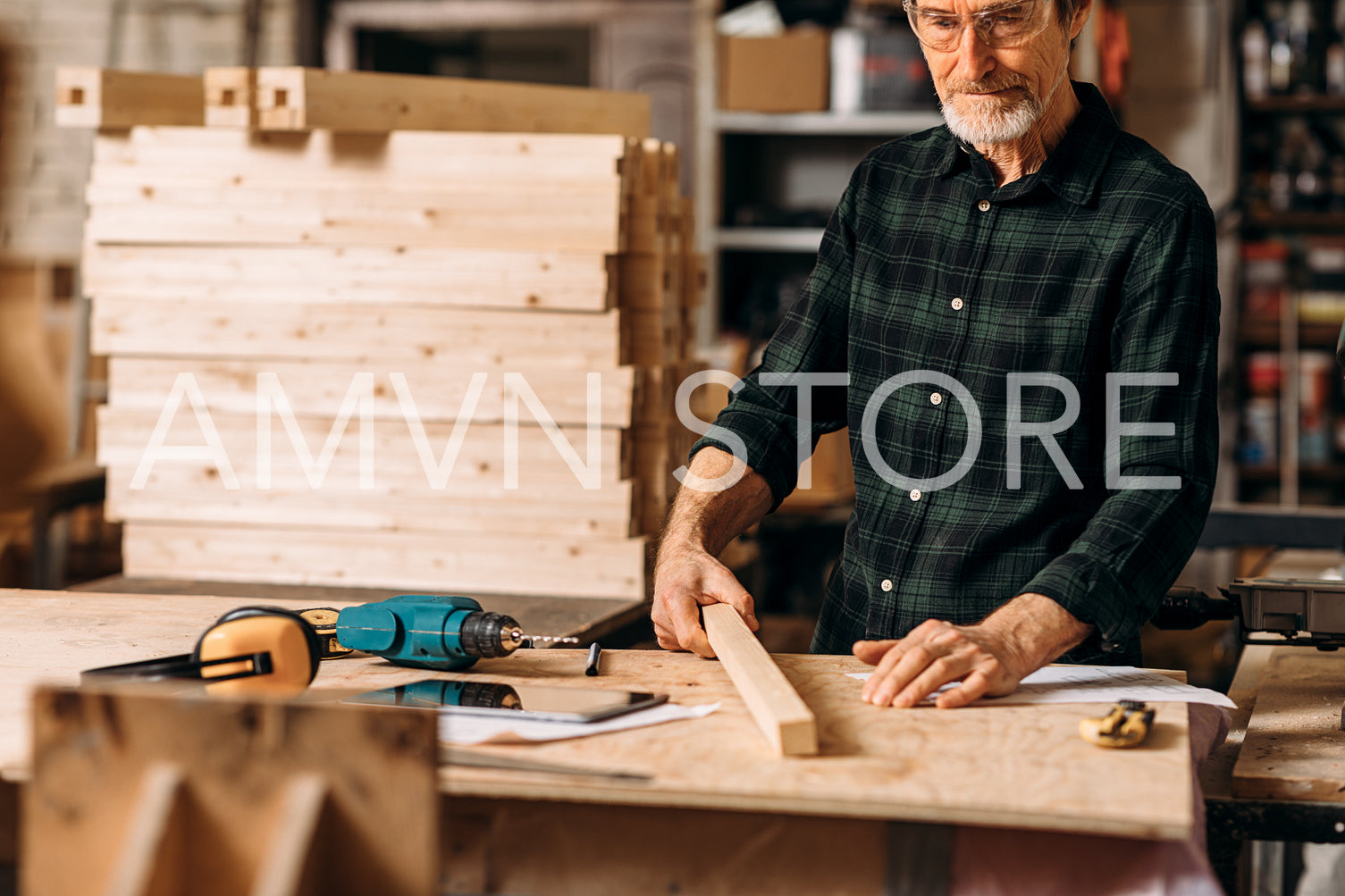 Cropped shot of mature carpenter standing at workbench in workshop	